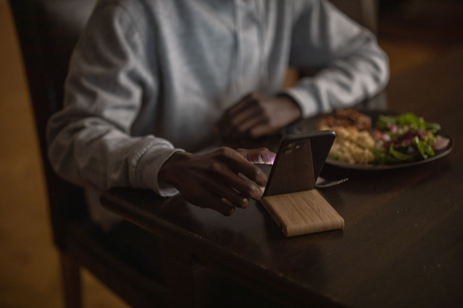 Person sitting calmly at a table, eating a meal slowly without phone or screen distractions