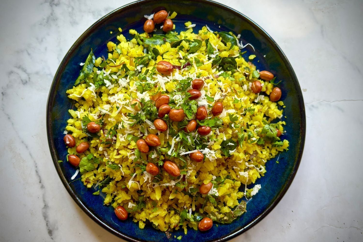 Pre-workout meal of poha with peanuts and a banana on a plate, an example of carbohydrate-rich Indian food eaten before exercise