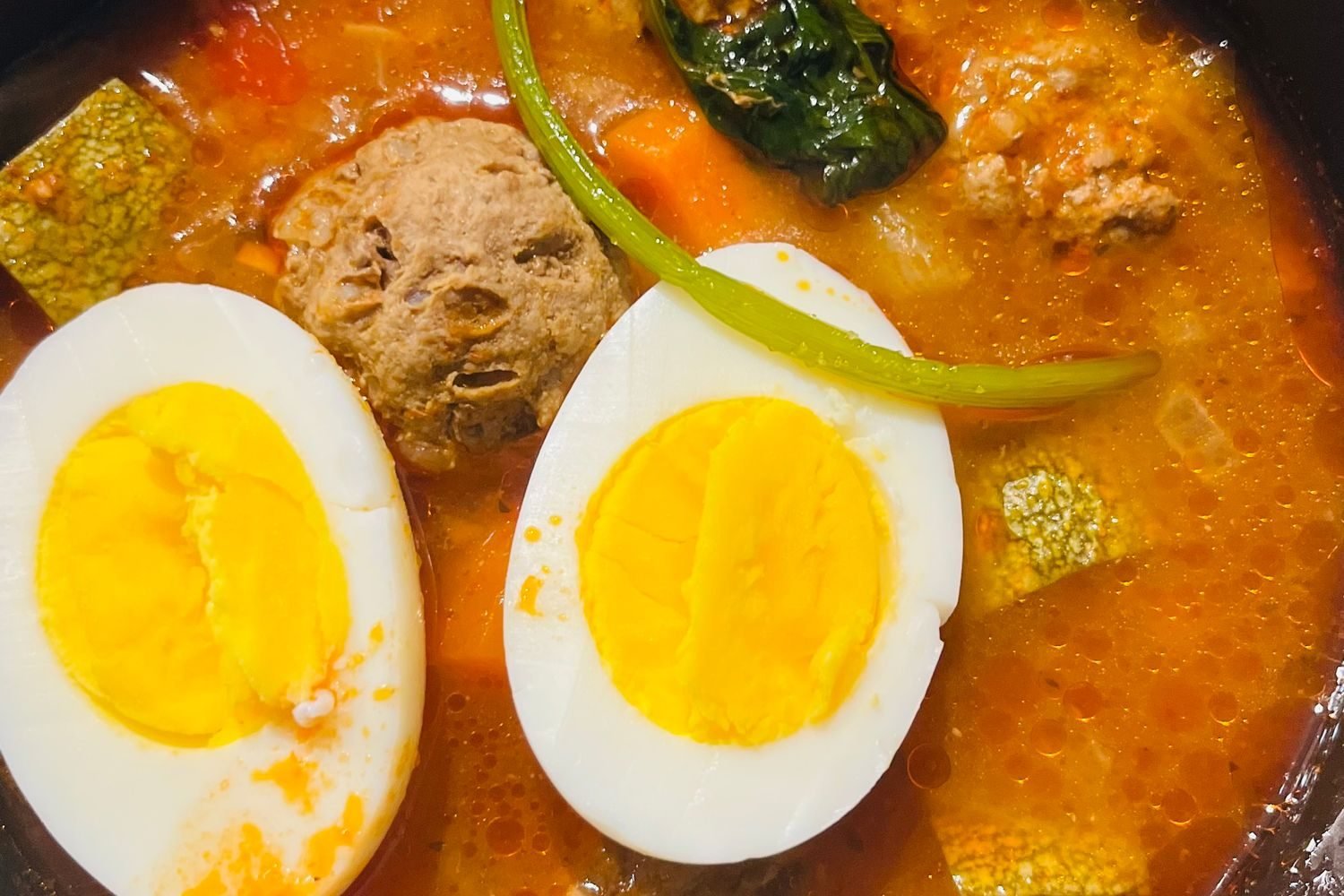 Person preparing a light soup and boiled eggs as an easy meal to break a fast